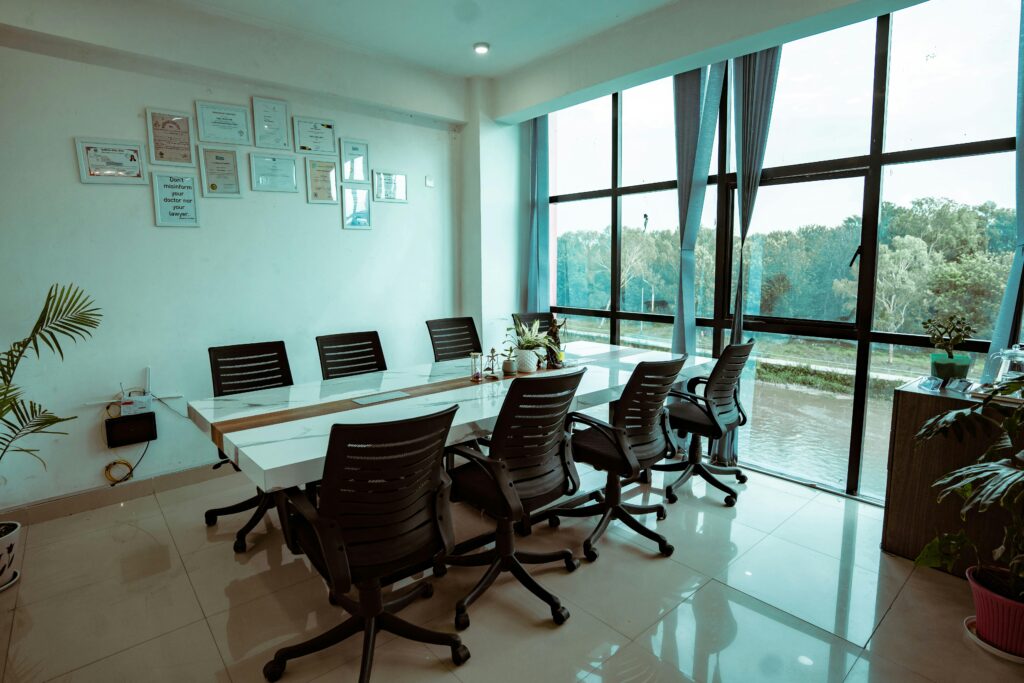 Modern office meeting room with large windows overlooking greenery, promoting productivity and collaboration.