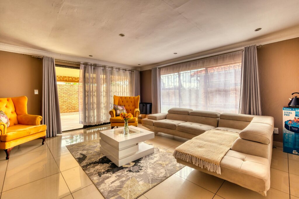 Cozy modern living room with vibrant chairs, neutral sofa, and natural light.